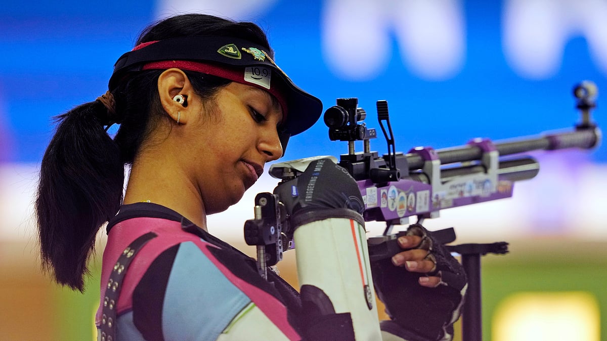 (AP Photo/Manish Swarup) : India's Ramita Jindal looks at her rifle as he competes in the 10m air rifle mixed team qualification round at the 2024 Summer Olympics, Saturday, July 27, 2024, in Chateauroux, France. 